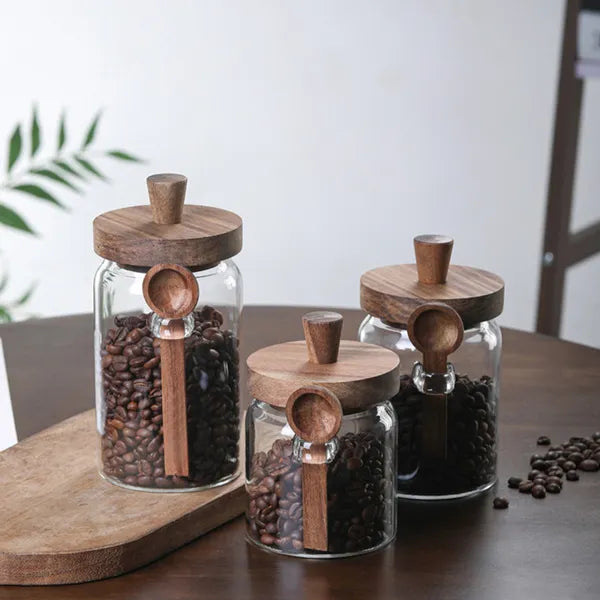 Glass coffee storage jars with wooden lids and spoons lifestyle shot
