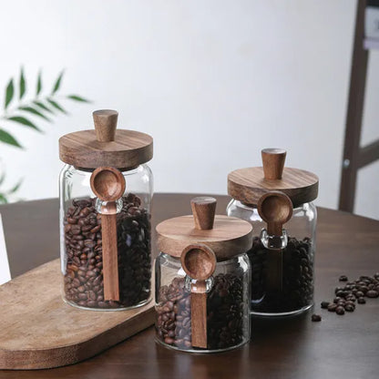 Glass coffee storage jars with wooden lids and spoons lifestyle shot